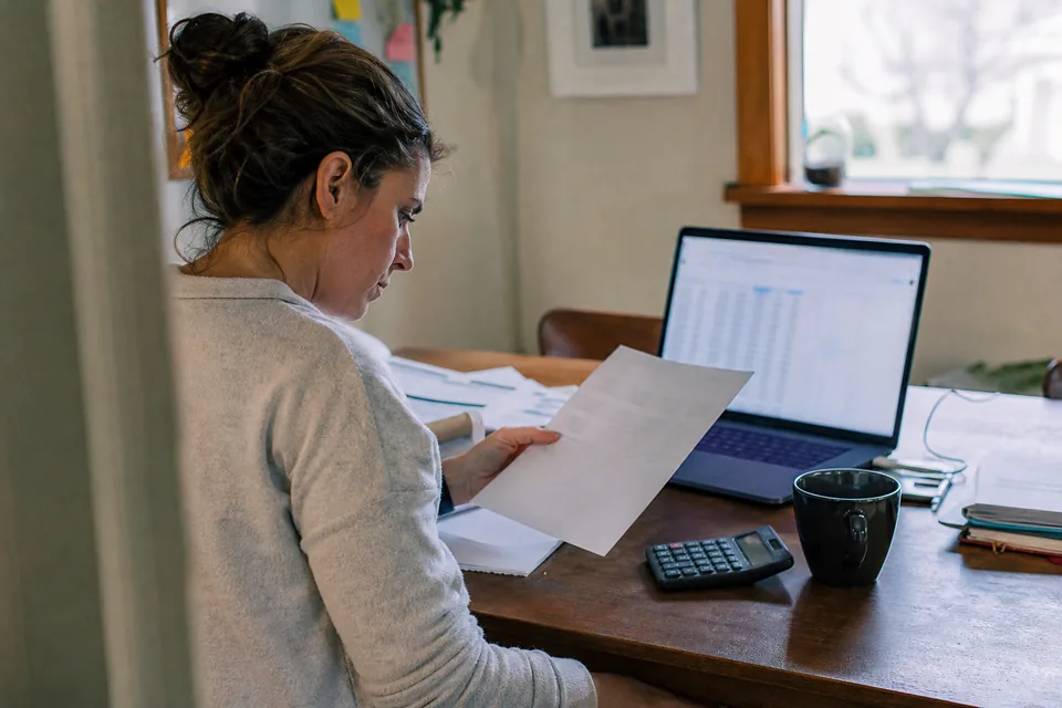 Hiring manager reviewing a monthly job ad budget and invoice at a desk