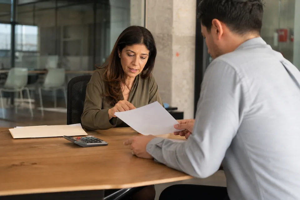 Hiring manager and recruiter reviewing an offer letter for a marketing hire